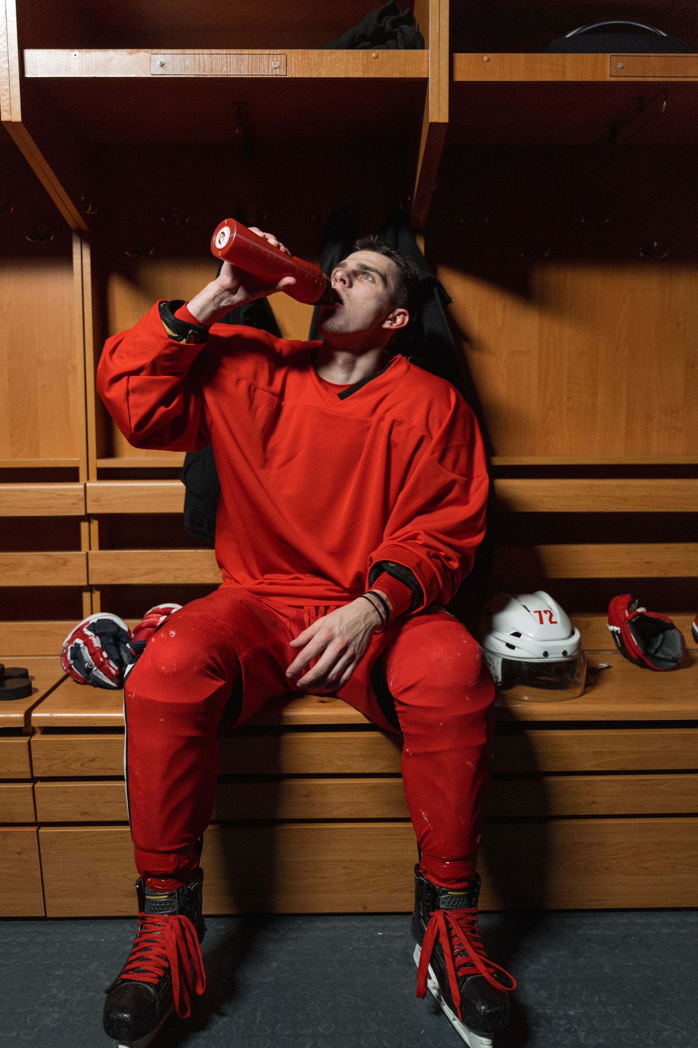 Hockey player in a dressing room using a squeeze bottle